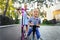 Two Cute adorable little caucasian siblings boy in shirt and girl in dress having fun riding three-wheel balance run