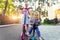 Two Cute adorable little caucasian siblings boy in shirt and girl in dress having fun riding three-wheel balance run