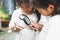 Two cute asian child girls using magnifying glass watching and learning on grasshopper that stick on hand with curious and fun