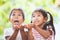 Two cute asian child girls waiting candies falling from the sky