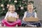 Two cute beauty children sitting at chritsmas tree with present boxes