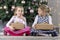 Two cute beauty children sitting at chritsmas tree with present boxes