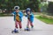 Two cute boys, compete in riding scooters, outdoor in the park