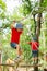 Two cute children, boy brothers, climbing in a rope playground s