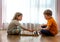 Two cute children playing chess at home or kindergarten. Table game. Preschool boy and girl play on the floor with