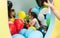 Two cute girls talking while playing with multicolored balloons