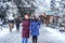 Two cute girls are walking around the Christmas city in winter. Women on the background of a festive snowy city
