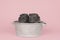 Two cute grey guinea pigs sitting next to eachother in a pewter tin bath on a pink background