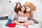 Two cute happy sisters using laptop in children room