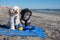 Two cute Havanese Jewish puppy dogs sit on a blue towel on the beach near the ocean with their Hannukah toy dreidel and kosher