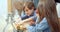 Two cute kids boy and girl rolling out cookie dough helping mom in the kitchen