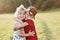 Two cute kids hugging each other outside, near the beautiful woods.