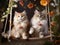 Two cute kittens sitting on a swing under a flowering tree.