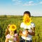 Two cute litle girls hiding behind sunflowers