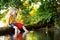 Two cute little girls having fun by a river at beautiful summer evening