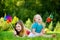 Two cute little girls holding colorful toy pinwheels on warm and summer day