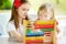 Two cute little girls playing with abacus at home. Big sister teaching her sibling to count. Smart child learning to count.