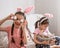 Two cute little girls posing in bunny ears with Easter eggs