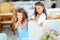 Two cute little girls standing in jumpers and sun glasses on the terrace background in the studio. Summer, fun, family