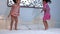 Two cute little girls in swimming suit having fun jumping on the bed at the resort. Childhood happiness.