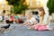 Two cute little sisters feeding birds on summer day. Children feeding pigeons and sparrows outdoors.