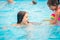 Two cute little sisters girls swim in the pool