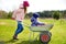 Two cute little sisters helping in a garden. Children taking part in outdoor household chores