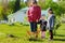 Two cute little sisters helping their grandmother in a garden. Children taking part in outdoor household chores