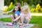 Two cute little sisters painting on stones together