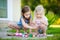 Two cute little sisters painting on stones together