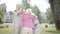 Two cute mature couples hugging in the park together standing in circle. Double date of senior couples. Friendly company