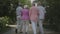 Two cute mature couples walking and talking in the summer park. Double date of senior couples. Friendly company resting