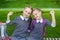 Two cute schoolgirls are sitting on a bench and smiling. the sisters are happy to go back to school. redheads pigtails