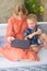 Two cute siblings brother and sister sitting on sofa at home and playing on wireless tablet together