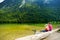 Two cute sisters enjoying the view of deep green waters of Konigssee, known as Germany`s deepest and cleanest lake, located in th