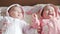 Two cute twin babies sisters lying on a blanket