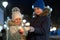 Two cute young children, boy and girl in warm winter clothing holding burning sparkler fireworks on dark night outdoors bokeh
