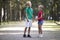 Two cute young laughing children, girl and boy, brother and sister having fun on blurred bright sunny summer park alley green