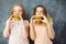 Two cute young women eating delicious burgers