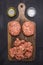 Two cutlets for burgers with minced meat on a cutting board with herbs, butter and salt wooden rustic background top view close