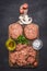 Two cutlets for burgers with minced meat, herbs, butter and salt wooden rustic background top view close up