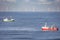 Two cutters passing each other with wind turbines of a windfarm in the background