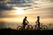 Two cyclists posing with bikes against amazing sky background.