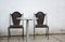 Two dark chairs against white wall welcoming guests