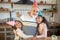 Two dark-skinned girls in bday hats hugging their granddad