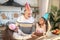 Two dark-skinned girls giving birthday cake to their granddad
