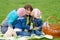 Two daughters kissing mother while on a picnic