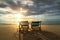 Two deckchairs on the beach at sunset with a tropical sea background. Travel and Vacation in Summer at sea