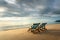 Two deckchairs on the beach at sunset with a tropical sea background. Travel and Vacation in Summer at sea