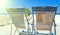 Two deckchairs on the roof of building on Santorini island, Greece. View on Caldera and Aegean sea, sunny day, blue sky.